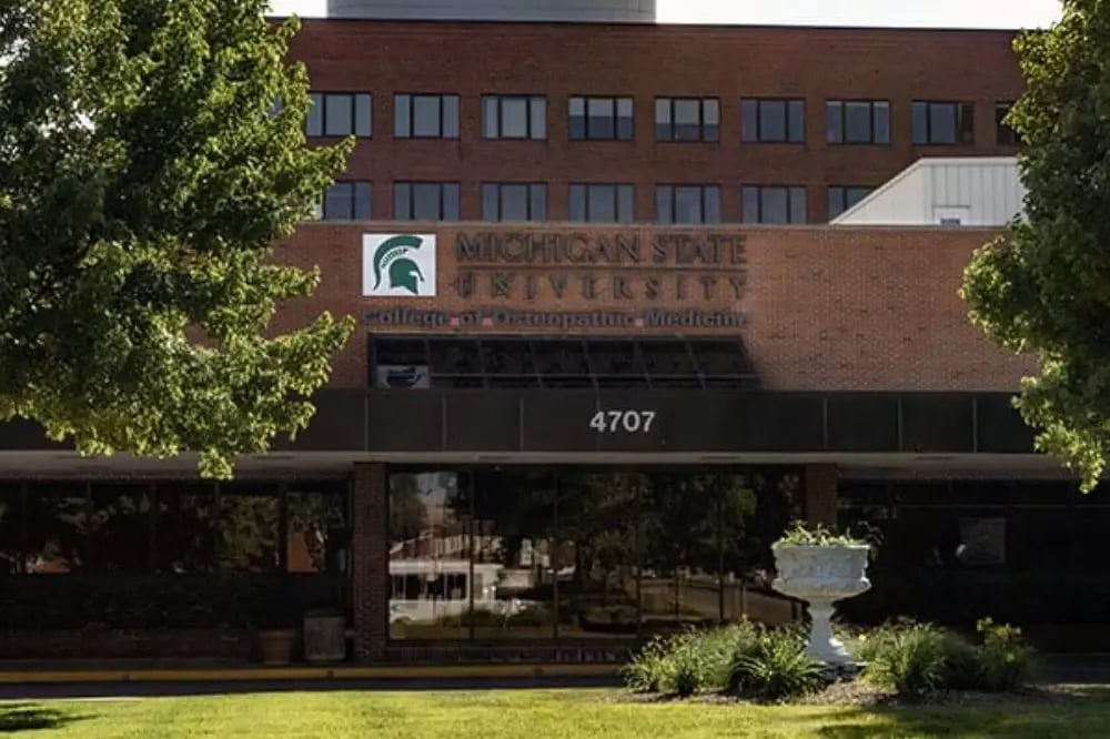 Front building view of the Michigan State University College of Human Medicine with the name of the school and school logo on the font of the building.