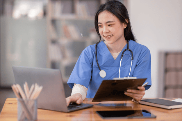 Woman in scrubs leading tutoring session on laptop.