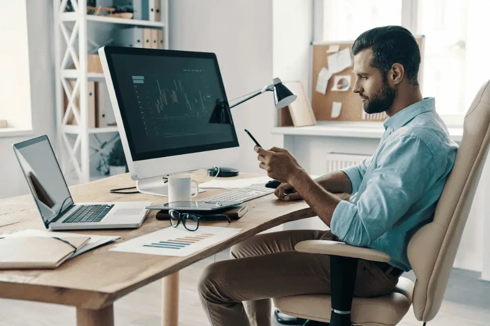 medical student sitting at his home desk, calculating the costs of medical school and related expenses