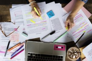 woman with paperworks and a laptop on her desk