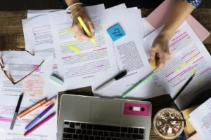 woman with paperworks and a laptop on her desk