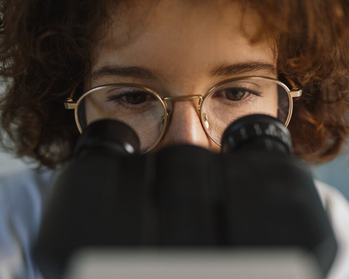 Woman looking through microscope