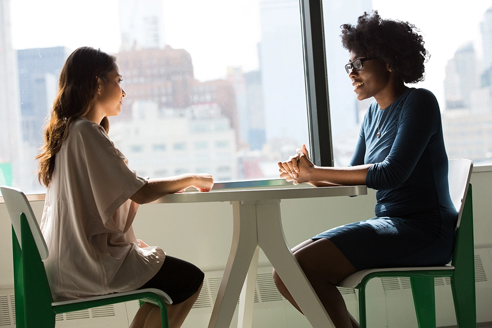 two women having a discussion at a table