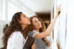 two female high school students checking a board at school, planning for pre-med undergraduate school