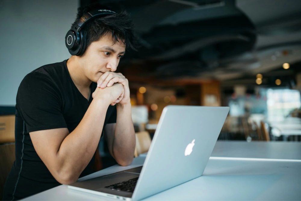 Student setting at a desk reading an email.